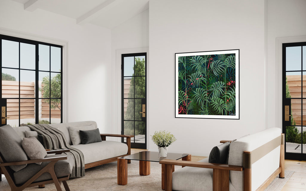 'Forever Green' fine art print by Jasmine Marshall framed in black, featured in a white living room with glass doors overlooking the garden.