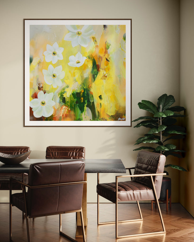 A 'Fresh Start' Fine Art Print by Jasmine Marshall, framed in black/oak. Premium Giclée print features white anemone flowers atop cream, lime green, yellow, and brown abstract details, featured in a neutral home interior with a dark wood dining table and plant.