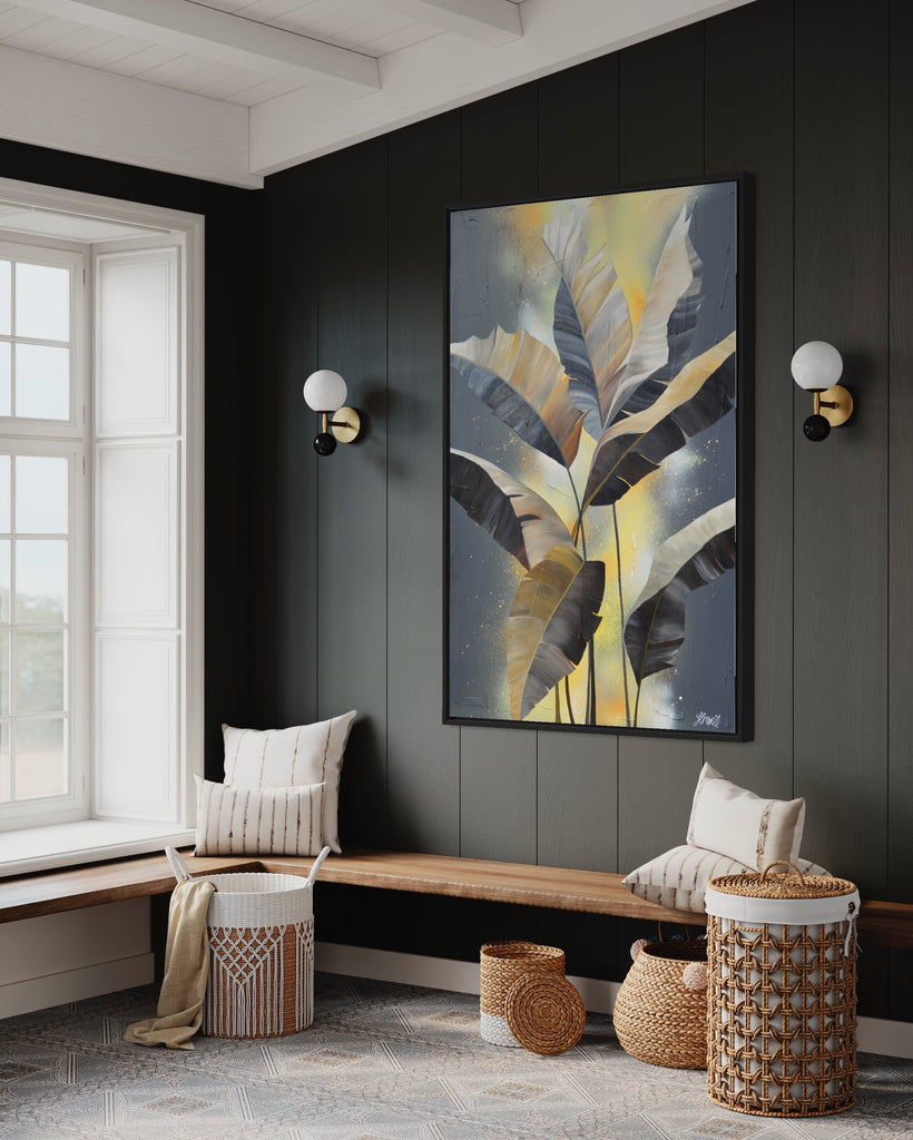 'Bittersweet' original acrylic painting by Jasmine Marshall framed in black/oak. Canvas painting features grey palm leaves on an abstract yellow background. Featured in a neutral home interior.