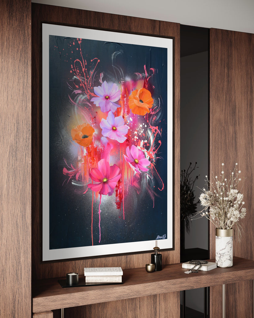 A 'Drama Tropicana' Fine Art Print by Jasmine Marshall, framed in black/oak. Premium Giclée print features white orange poppies and pink and purple flower on an abstract navy background, featured in a neutral home interior on a wooden wall.