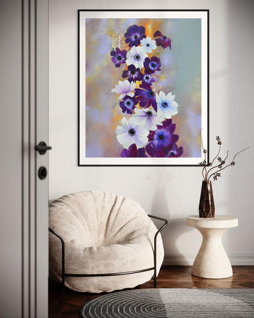 ‘Flourish' Fine Art Print by Jasmine Marshall, framed in black/oak. Premium Giclée print features white and purple anemone flowers on a grey and lilac abstract background, featured in a neutral home interior with a white chair and table with grey door.