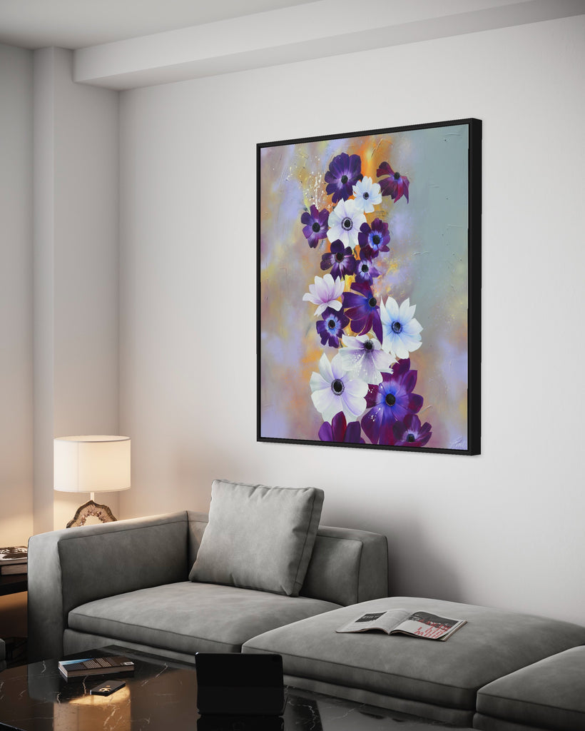 'Flourish' original painting on a cotton canvas by Jasmine Marshall, framed in black/oak. Features white and purple anemone flowers on a grey and lilac abstract background, featured in a neutral home interior. with a grey sofa and black marble table with ipad.