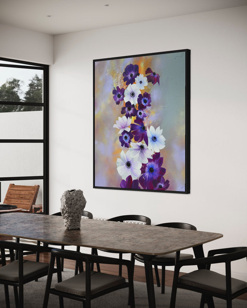 'Flourish' original painting on a cotton canvas by Jasmine Marshall, framed in black/oak. Features white and purple anemone flowers on a grey and lilac abstract background, featured in a dining room with black dining table and glass doors.