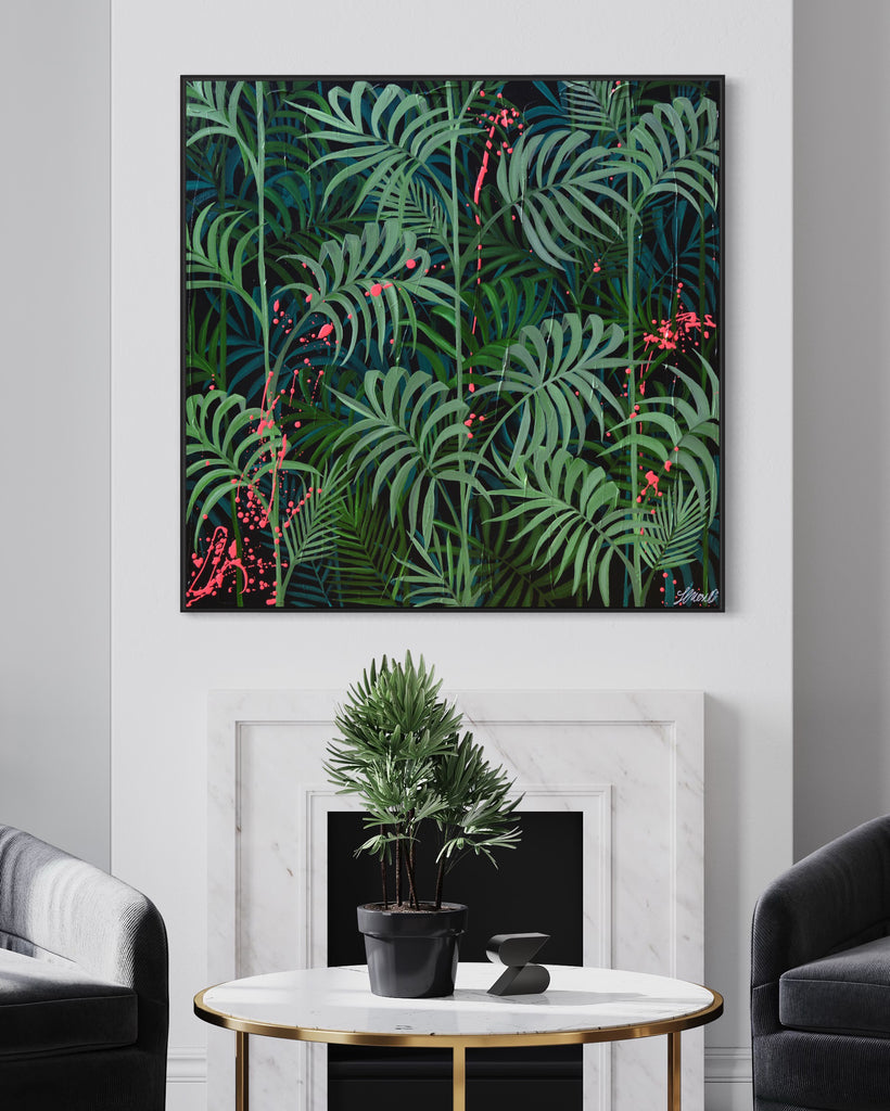 'Forever Green' original painting on a cotton canvas by Jasmine Marshall, framed in black/oak. Features layers of palm leaves on a black background with pops on neon pink.  Displayed in a neutral home interior, over a marble fireplace with grey armchairs and a marble coffee table.