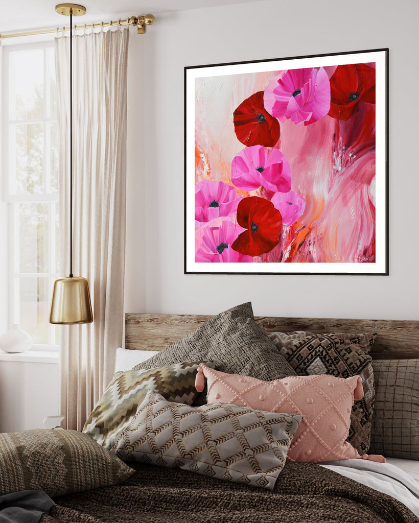 ‘It’s a Forever Thing' Fine Art Print by Jasmine Marshall, framed in black/oak. Premium Giclée print features pink and red poppies on an abstract background with pops of orange.  Displayed above a wooden bed frame with cushions and gold furnishings.