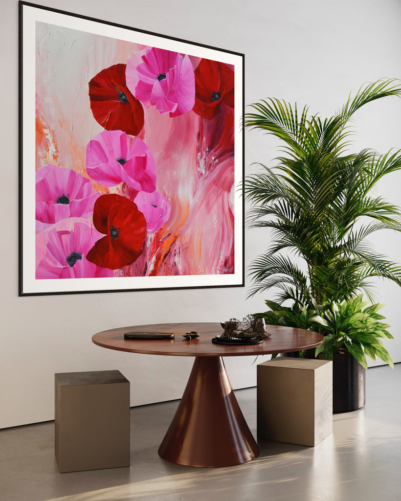 ‘It’s a Forever Thing' Fine Art Print by Jasmine Marshall, framed in black/oak. Premium Giclée print features pink and red poppies on an abstract background with pops of orange.  Displayed in a neutral home interior with a plant and wooden table.