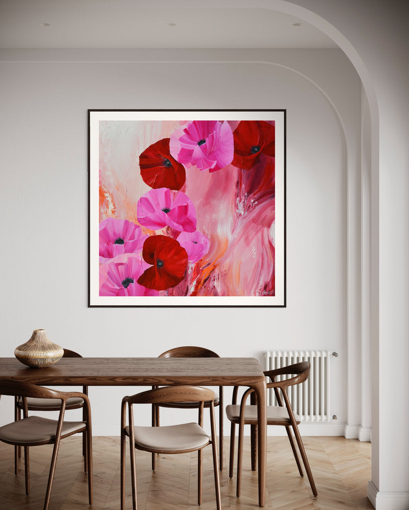 ‘It’s a Forever Thing' Fine Art Print by Jasmine Marshall, framed in black/oak. Premium Giclée print features pink and red poppies on an abstract background with pops of orange.  Displayed in a white kitchen with wooden dining table..