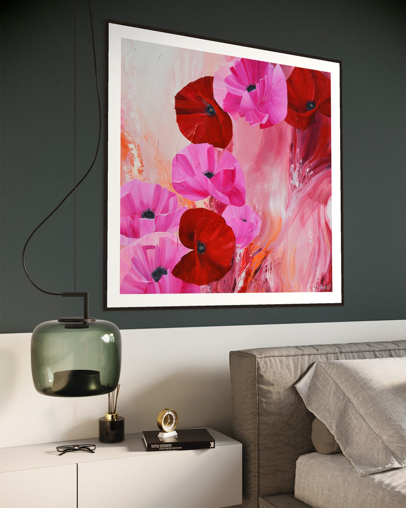 ‘It’s a Forever Thing' Fine Art Print by Jasmine Marshall, framed in black/oak. Premium Giclée print features pink and red poppies on an abstract background with pops of orange.  Displayed in a neutral home interior above a grey bed.