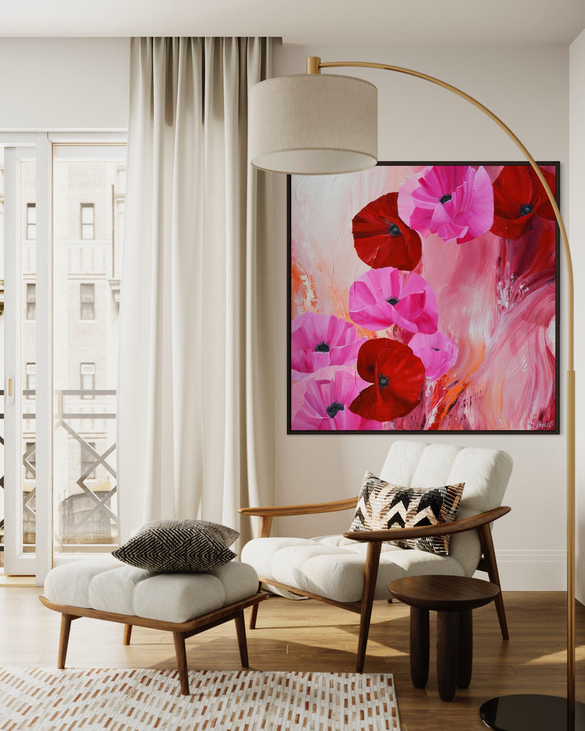 'It’s a Forever Thing' original painting on a cotton canvas by Jasmine Marshall, framed in black/oak. Features pink and red poppies on an abstract background with pops of orange. Displayed in a neutral home interior. with cream chair and curtains.