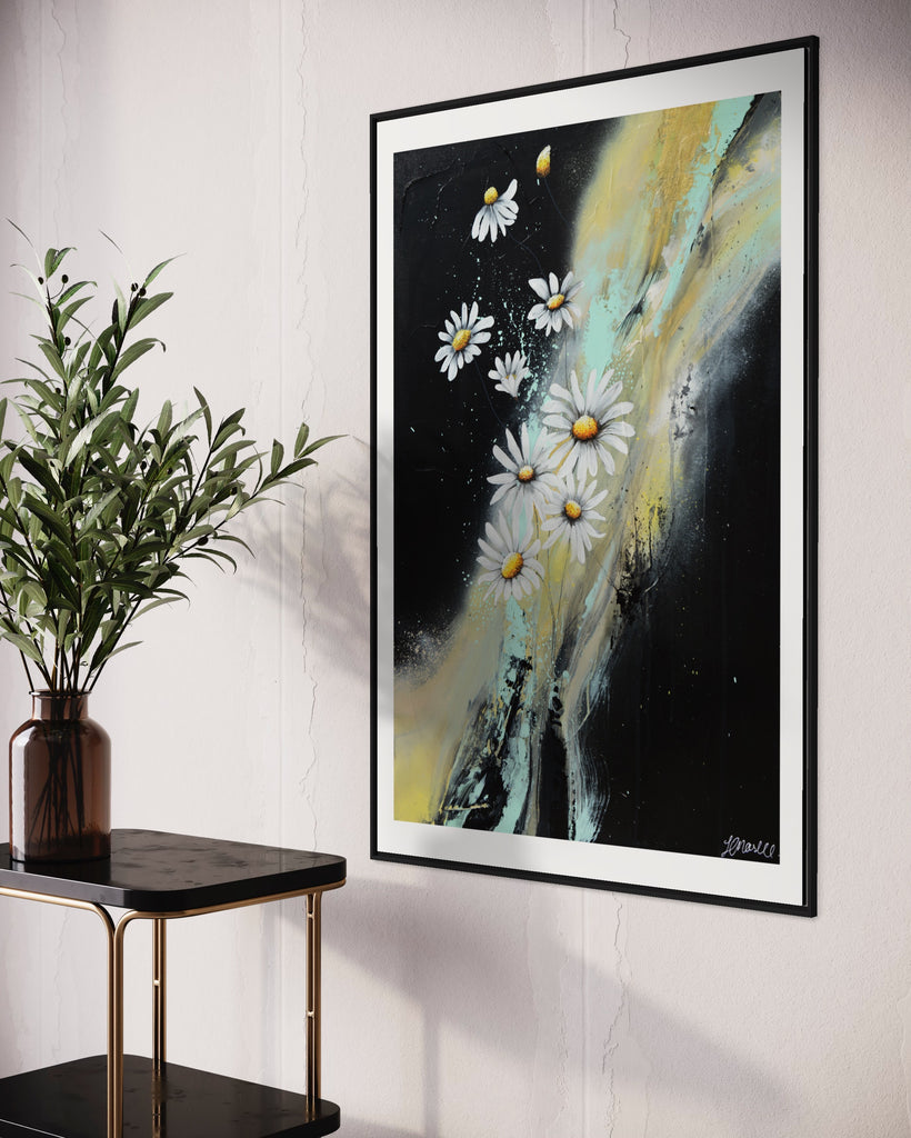 ‘Light in the Darkness' Fine Art Print by Jasmine Marshall, framed in black/oak. Premium Giclée print features white daisies on a black abstract background.  Displayed in a neutral home interior with a black and gold bar cart and plant.