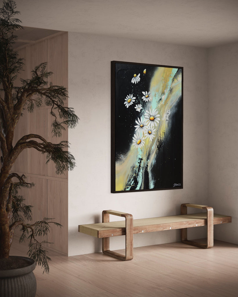 'Light in the Darkness' original painting on a cotton canvas by Jasmine Marshall, framed in black/oak. Features white daisies on a black abstract background. Displayed in a neutral home interior and plant