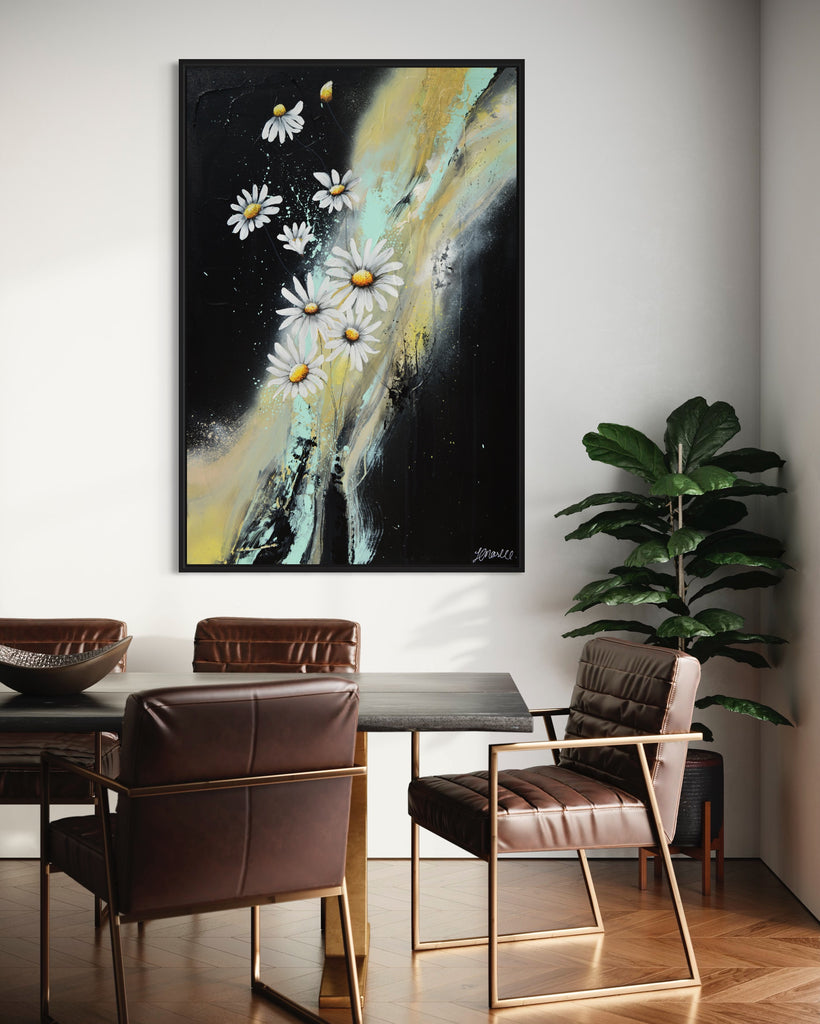 'Light in the Darkness' original painting on a cotton canvas by Jasmine Marshall, framed in black/oak. Features white daisies on a black abstract background. Displayed in a neutral home interior with wooden dining table.