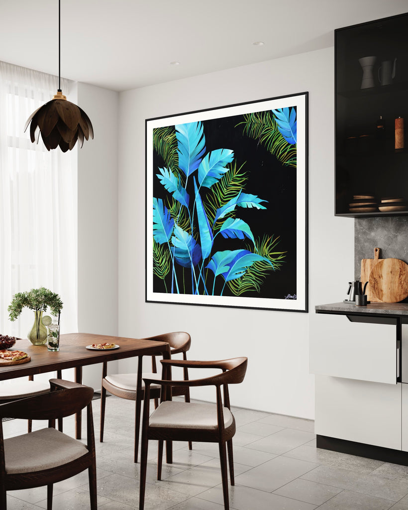 ‘Midnight Jungle' Fine Art Print by Jasmine Marshall, framed in black/oak. Premium Giclée print features turquoise palm leaves on a black background.  Displayed in a kitchen with wooden kitchen table.