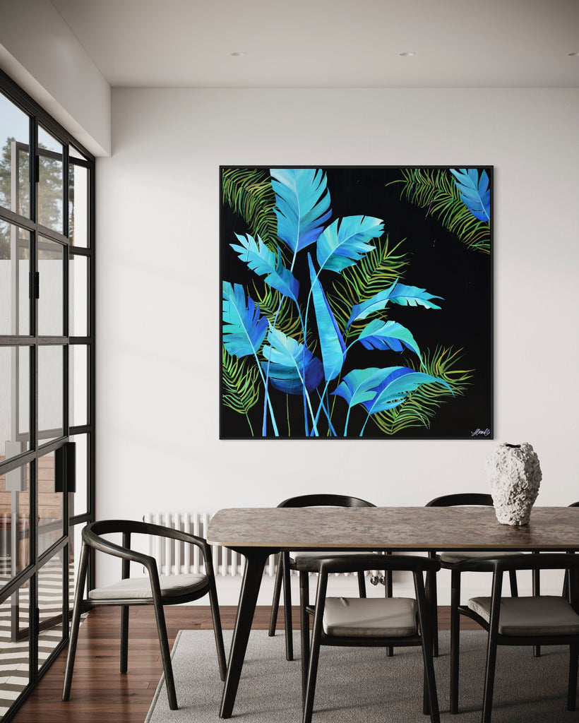 'Midnight Jungle' original painting on a cotton canvas by Jasmine Marshall, framed in black/oak. Features turquoise palm leaves on a black background. Displayed in a neutral home interior with black dining table.