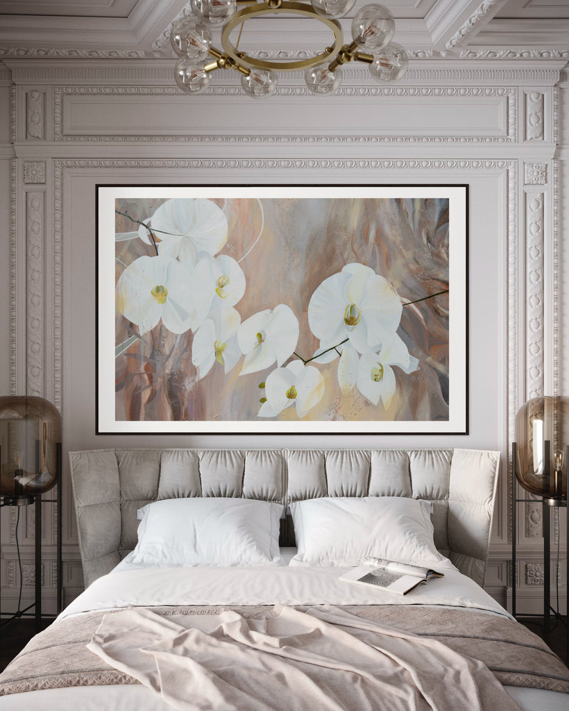 ‘Natural Elegance' Fine Art Print by Jasmine Marshall, framed in black/oak. Premium Giclée print features white orchids on a neutral brown, beige abstract background. Displayed in a neutral bedroom with chandelier.