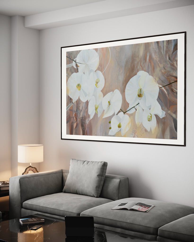 ‘Natural Elegance' Fine Art Print by Jasmine Marshall, framed in black/oak. Premium Giclée print features white orchids on a neutral brown, beige abstract background. Displayed in a neutral home interior with a grey sofa, black marble table, lamp and ipad.