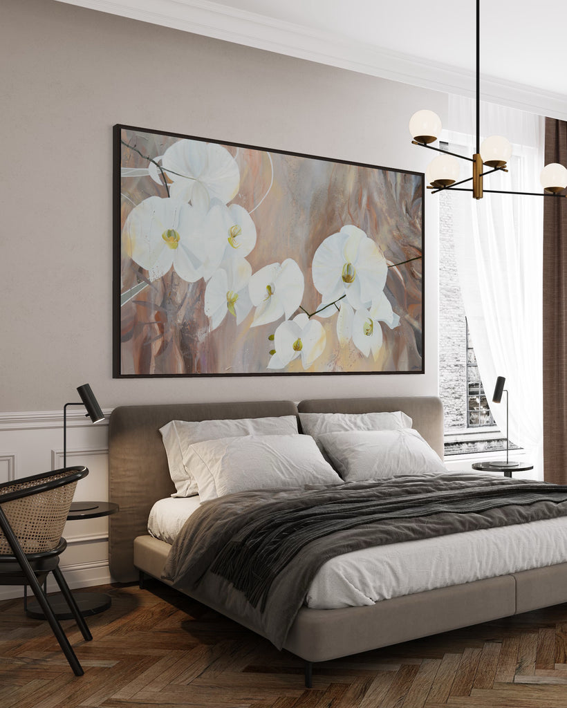 'Natural Elegance' original painting on a cotton canvas by Jasmine Marshall, framed in black/oak. Features white orchids on a neutral brown, beige abstract background. Displayed in a neutral bedroom with grey bedding.