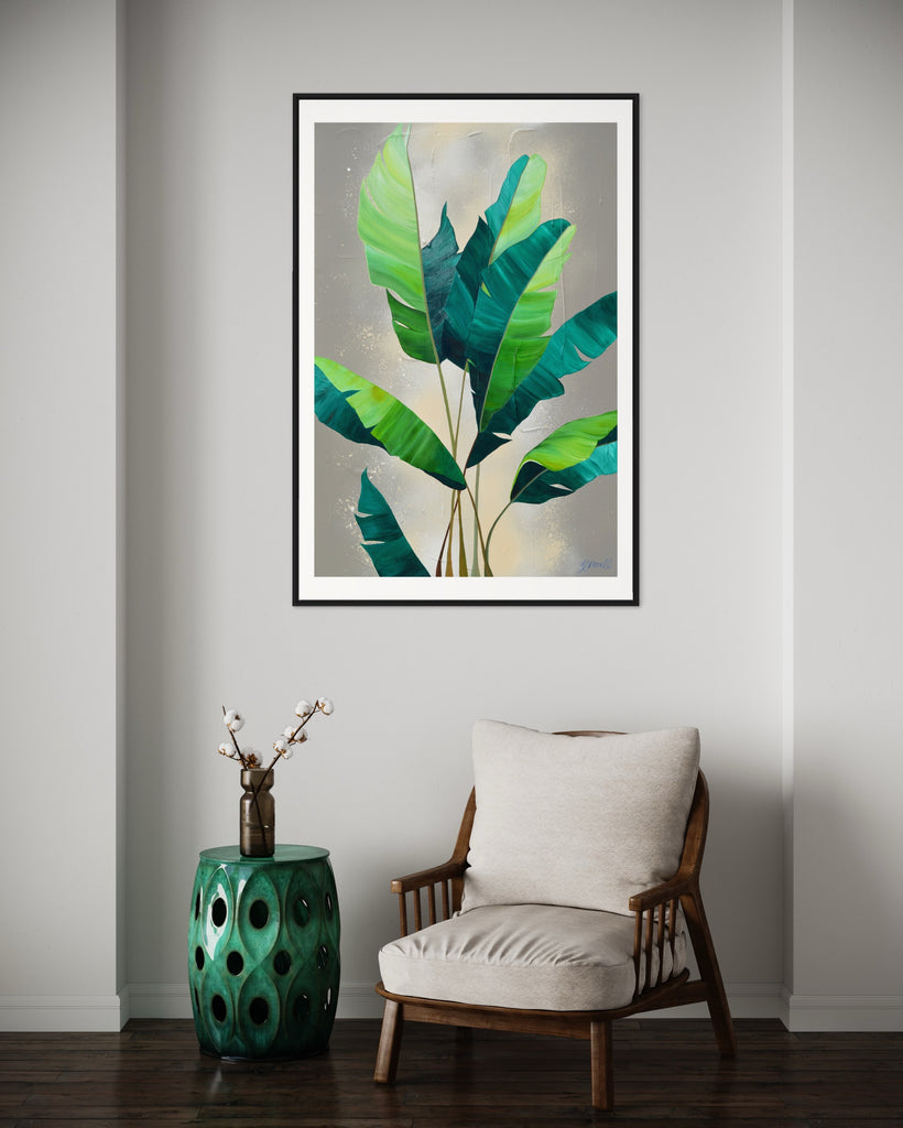 ‘Rainforest Glow' Fine Art Print by Jasmine Marshall, framed in black/oak. Premium Giclée print features green palm leaves on a neutral abstract painting. Displayed in a neutral home interior with a green decorative table and wooden chair.