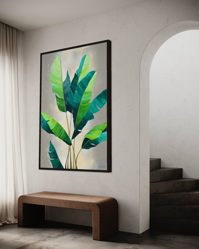 'Rainforest Glow' original painting on a cotton canvas by Jasmine Marshall, framed in black/oak. Features green palm leaves on a neutral abstract painting. Displayed in a neutral home interior.