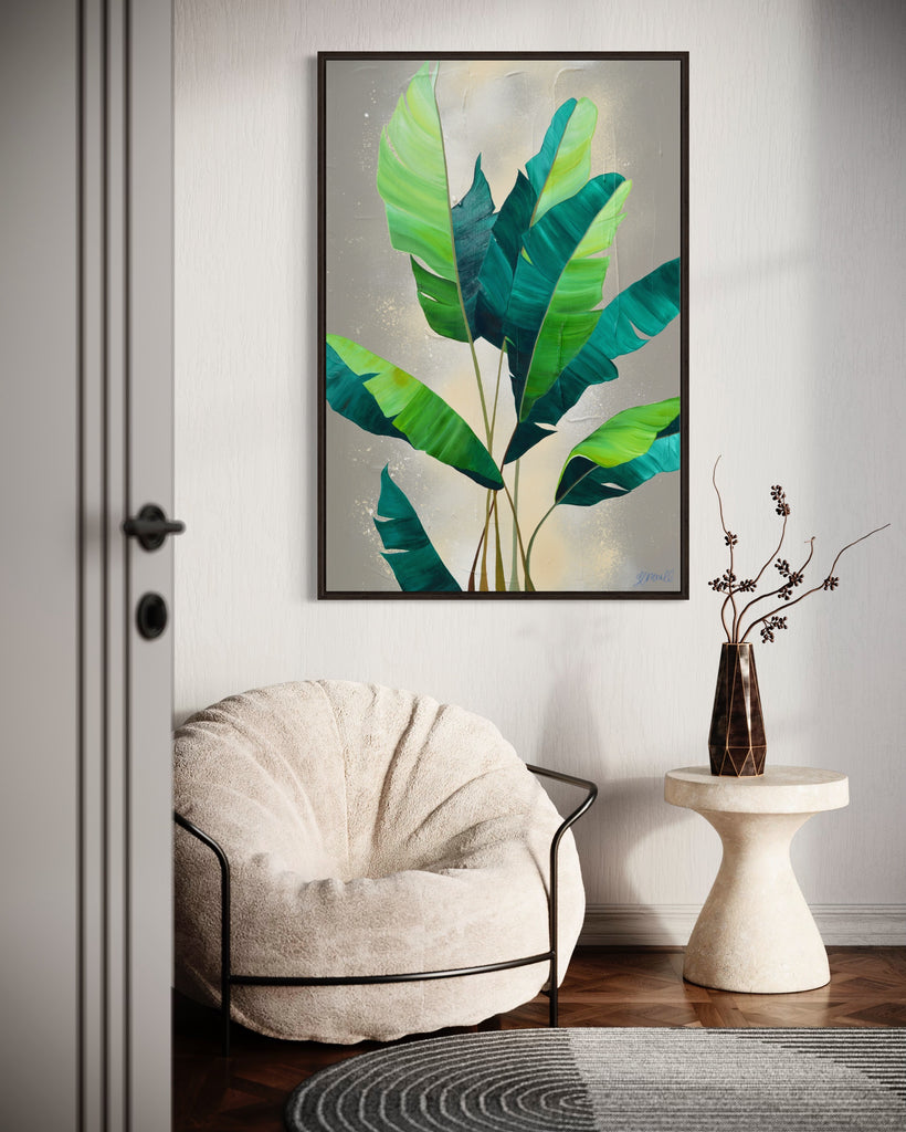 'Rainforest Glow' original painting on a cotton canvas by Jasmine Marshall, framed in black/oak. Features green palm leaves on a neutral abstract painting. Displayed in a neutral home interior.