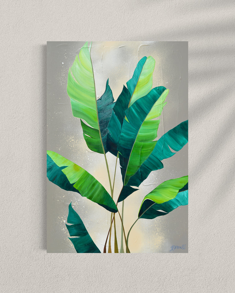 'Rainforest Glow' original painting on a cotton canvas by Jasmine Marshall, framed in black/oak. Features green palm leaves on a neutral abstract painting. Displayed in a gallery.