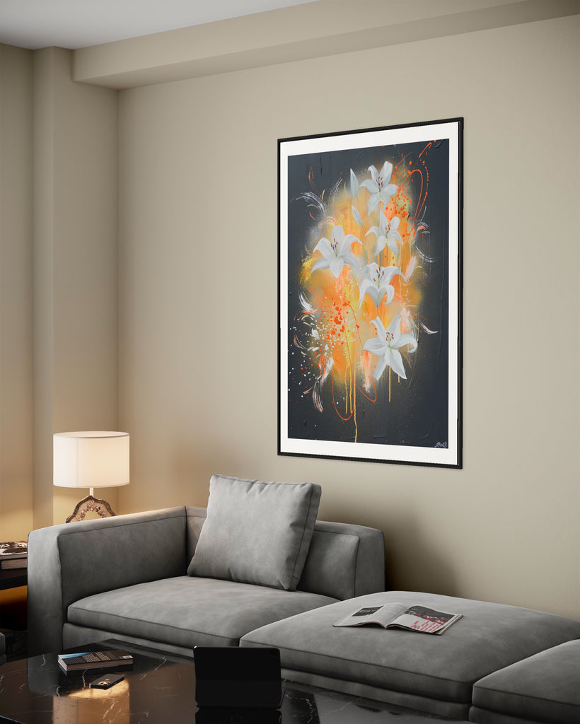 ‘Sweet Pollen' Fine Art Print by Jasmine Marshall, framed in black/oak. Premium Giclée print features white lilies on a grey textured background with pops of neon orange. Displayed in a neutral home interior with grey sofa, black marble coffee table, ipad and lamp.