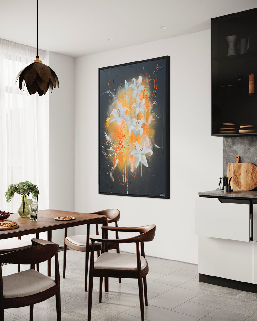 'Sweet Pollen' original painting on a cotton canvas by Jasmine Marshall, framed in black/oak. Features white lilies on a grey textured background with pops of neon orange. Displayed in a neutral kitchen with black units and a wooden dining table.