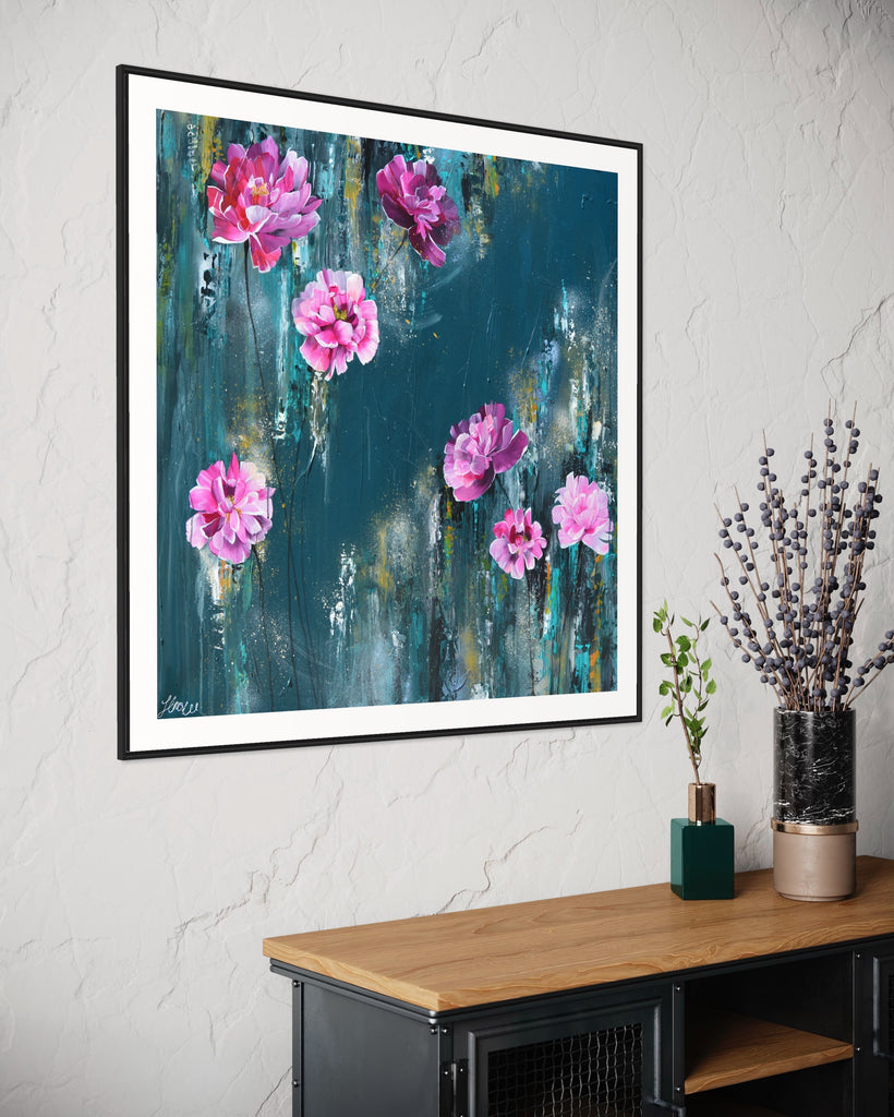 ‘The Other Side' Fine Art Print by Jasmine Marshall, framed in black/oak. Premium Giclée print features pink peonies on a teal background. Displayed above a black and wooden unit with flowers on.