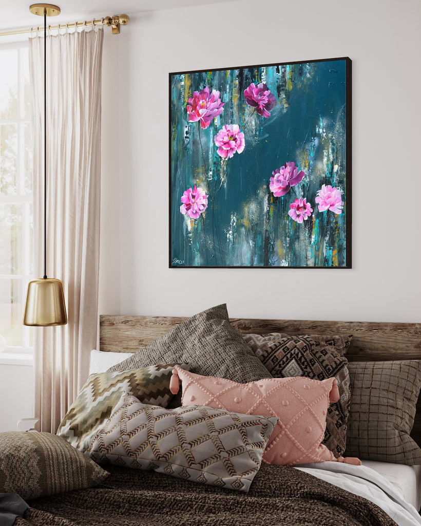 'The Other Side' original painting on a cotton canvas by Jasmine Marshall, framed in black/oak. Features pink peonies on a teal background. Displayed in a neutral home interior with wooden bed frame and cushions.