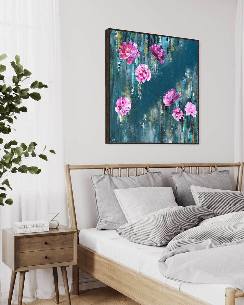 'The Other Side' original painting on a cotton canvas by Jasmine Marshall, framed in black/oak. Features pink peonies on a teal background. Displayed in a neutral home interior above a white bed.