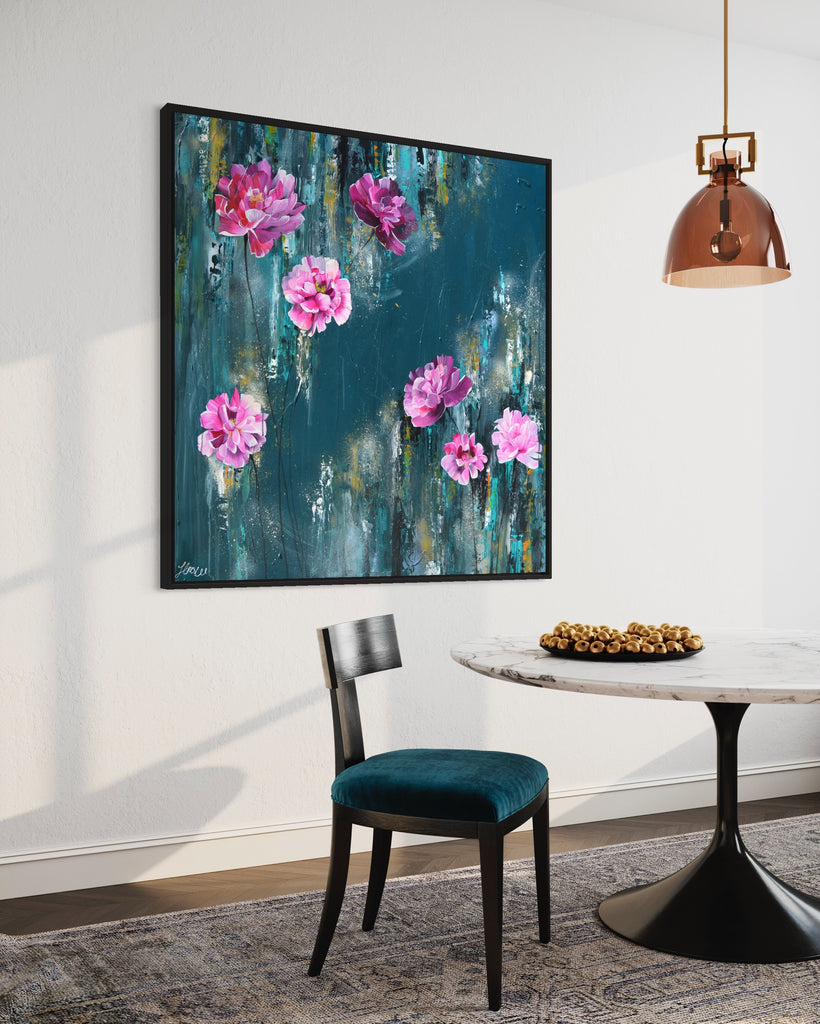 'The Other Side' original painting on a cotton canvas by Jasmine Marshall, framed in black/oak. Features pink peonies on a teal background. Displayed in a neutral home interior with rose gold ceiling lamp, white marble table and blue chair.