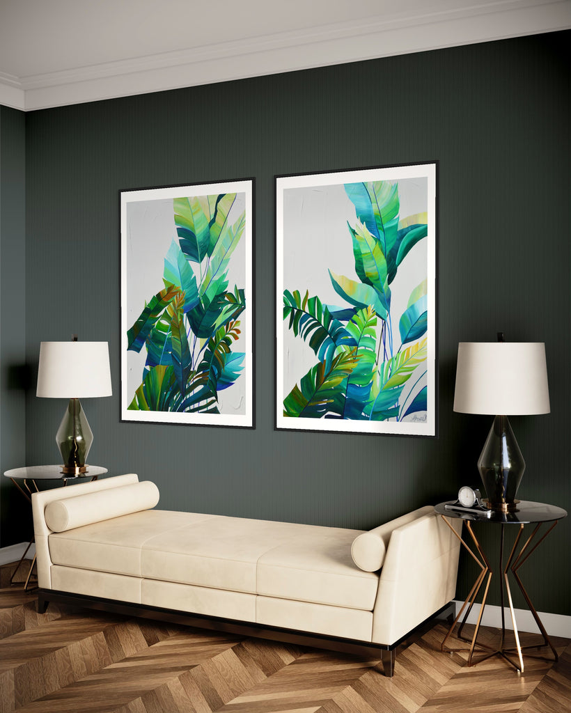 ‘Tropic Duo' Fine Art Print by Jasmine Marshall, framed in black/oak. Premium Giclée print features tropical blue and green leaves on a grey background. Displayed in a living room with green walls and white sofa.