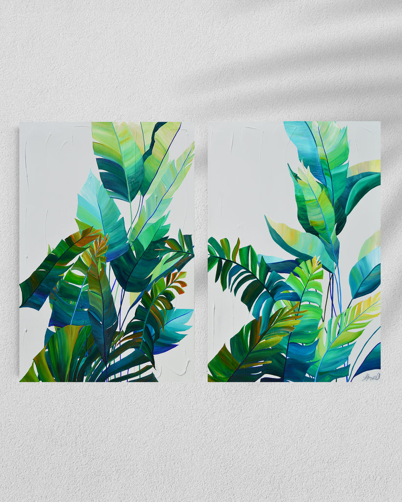 'Tropic Duo' original painting on a cotton canvas by Jasmine Marshall, framed in black/oak. Features tropical blue and green leaves on a grey background. Displayed in a gallery.