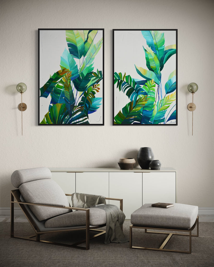 'Tropic Duo' original painting on a cotton canvas by Jasmine Marshall, framed in black/oak. Features tropical blue and green leaves on a grey background. Displayed in a neutral home interior.