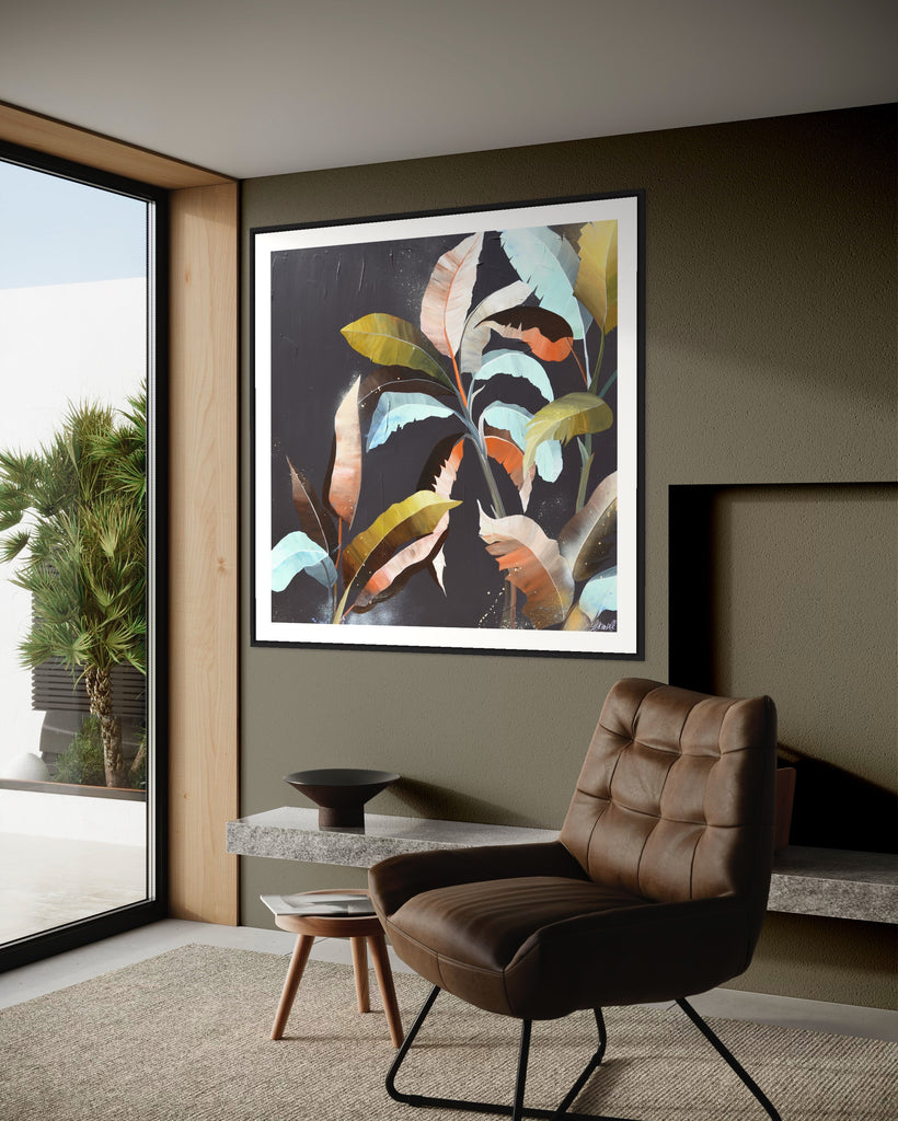 ‘Under the Canopy' Fine Art Print by Jasmine Marshall, framed in black/oak. Premium Giclée print features a palm tree on a brown background with abstract details. Displayed on a green wall next to a window over looking the garden with a brown chair.