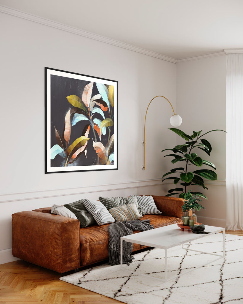 ‘Under the Canopy' Fine Art Print by Jasmine Marshall, framed in black/oak. Premium Giclée print features a palm tree on a brown background with abstract details. Displayed in a living room with a brown sofa, white rug and green plant.