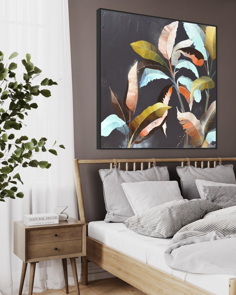 'Under the Canopy' original painting on a cotton canvas by Jasmine Marshall, framed in black/oak. Features a palm tree on a brown background with abstract details. Displayed in a neutral home on a grey wall above a white bed.