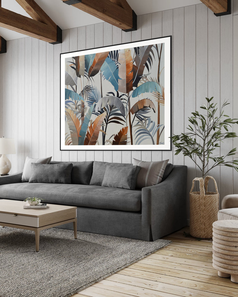 ‘Virgin Forest' Fine Art Print by Jasmine Marshall, framed in black/oak. Premium Giclée print features brown, blue, black leaves on a neutral background. Displayed in a neutral home interior with wooden ceiling beams, grey walls, plant and grey sofa.