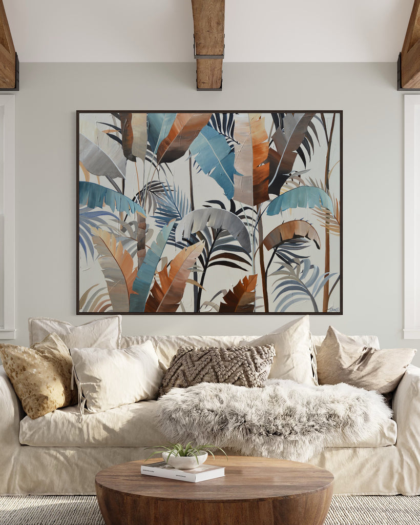 'Virgin Forest’ original painting on a cotton canvas by Jasmine Marshall, framed in black/oak. Features brown, blue, black leaves on a neutral background. Displayed in a neutral living room with a white sofa and wooden table.