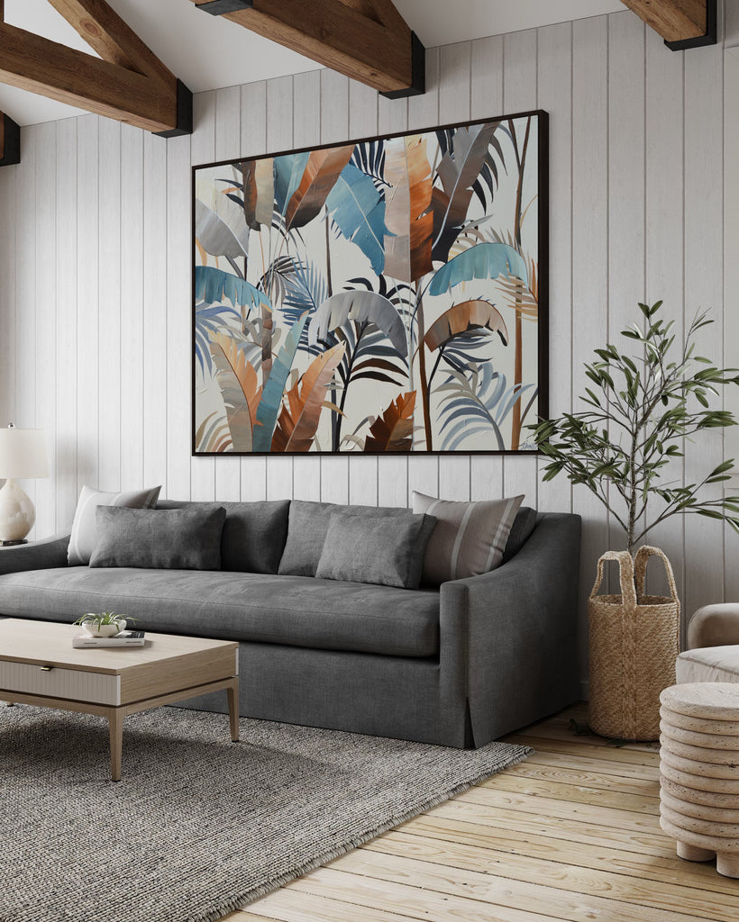 'Virgin Forest’ original painting on a cotton canvas by Jasmine Marshall, framed in black/oak. Features brown, blue, black leaves on a neutral background. Displayed in a neutral living room with wooden ceiling beams, a plant and a grey sofa.