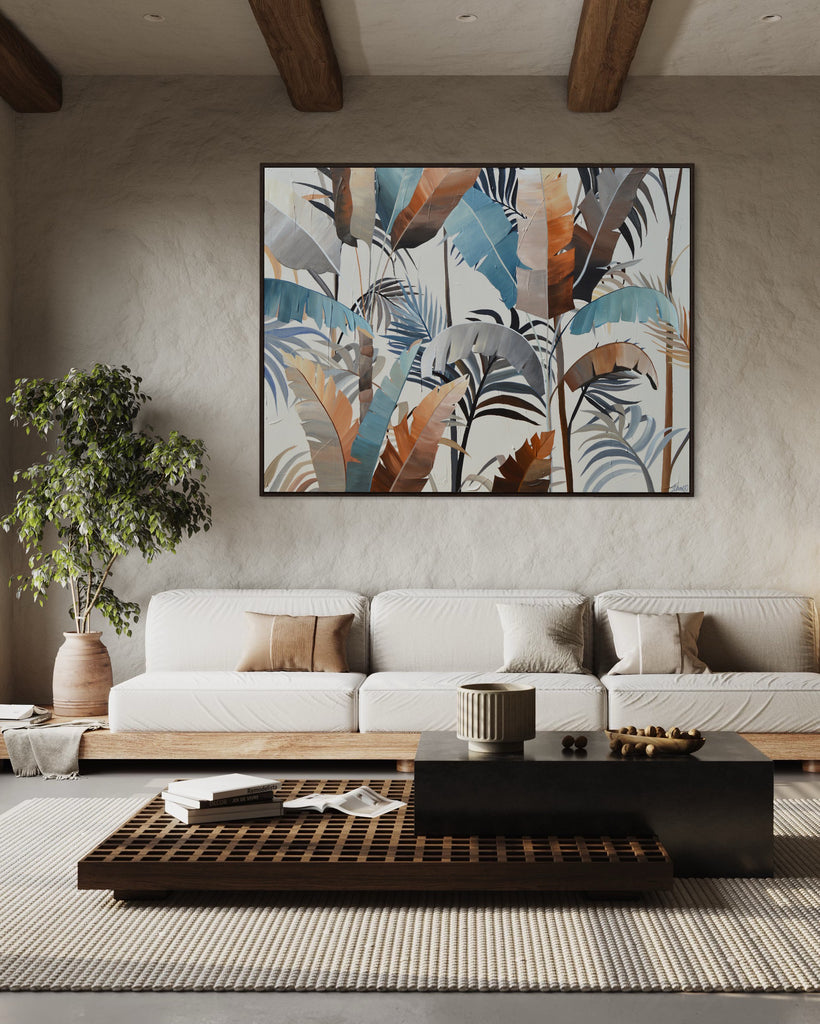 'Virgin Forest’ original painting on a cotton canvas by Jasmine Marshall, framed in black/oak. Features brown, blue, black leaves on a neutral background. Displayed in a neutral living room with cream sofa, wooden table, wooden ceiling beams and a plant.